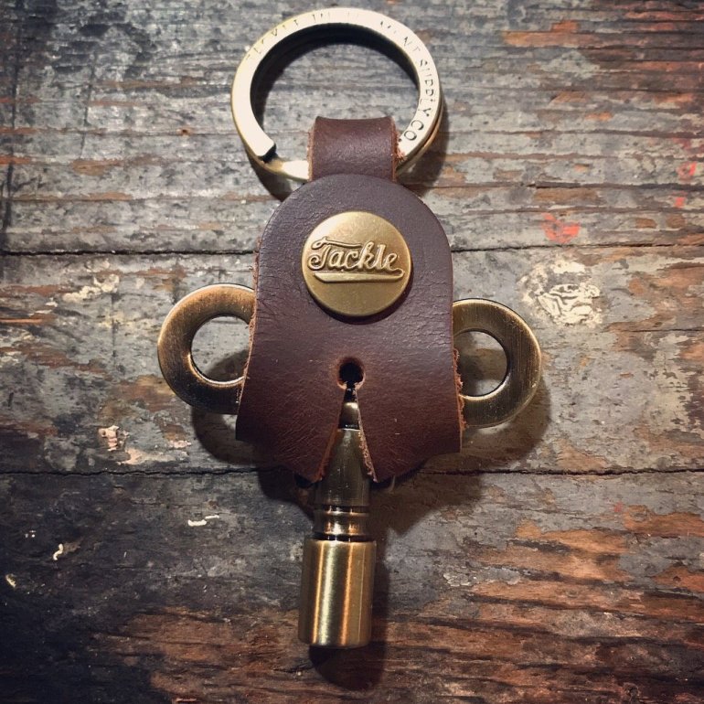 Timekeepers Drum Key from Tackle shown in antique brass at an old wooden surface